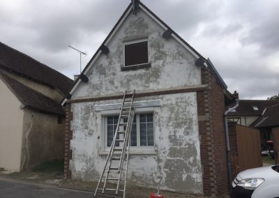 Photo d'une maison avec une façade usée.
